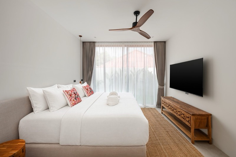 Bright bedroom with sheer curtains and a teak sideboard