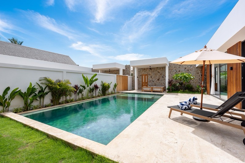 Pool with sun lounger and parasol beside the garden